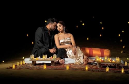 a man and a woman sitting on a blanket with candles at Rajputana Desert Camp in Jaisalmer