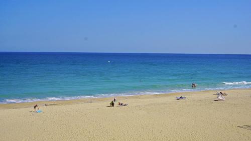 オブゾルにあるОбзор Бийч Апартаменти - Obzor Beach Apartmentsの海の近くのビーチにいる人々のグループ