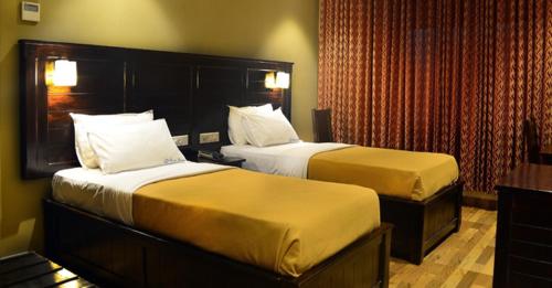 a hotel room with two beds in a room at Ranis Grand in Coimbatore