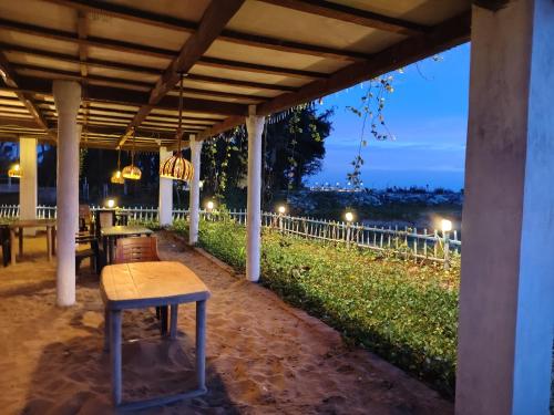 a table and chairs under a porch at night at Coconut tree cafe Gokarna in Gokarna