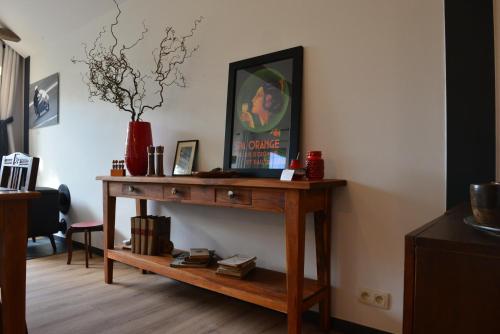 a wooden table in a living room with a vase at Le Clos des Brumes in Stoumont