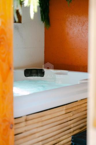a bathtub in a room with an orange wall at Signature Balneary, Spa & Sauna in Deauville