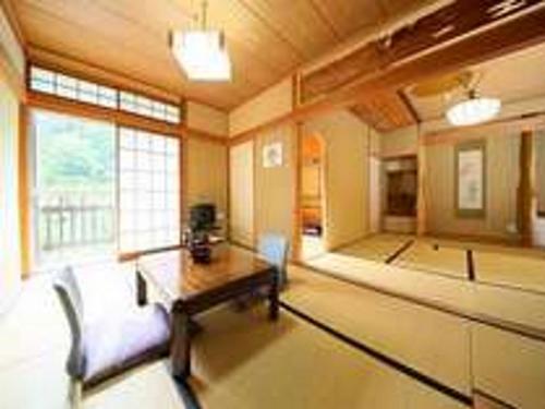 a living room with a couch and a table at Yama no Yado Meiji Onsen in Chino