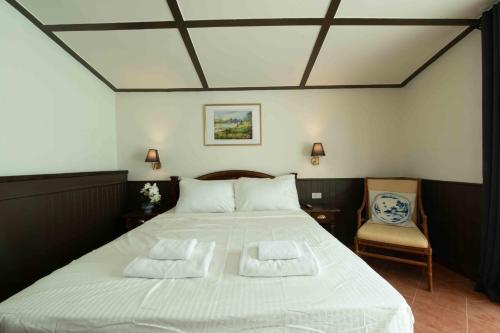 a bedroom with a large white bed with two pillows at Casa Acero in Bangkok