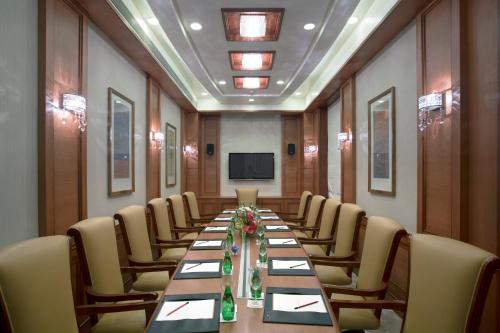 a conference room with a long table and chairs at Royal Tulip Navi Mumbai in Navi Mumbai
