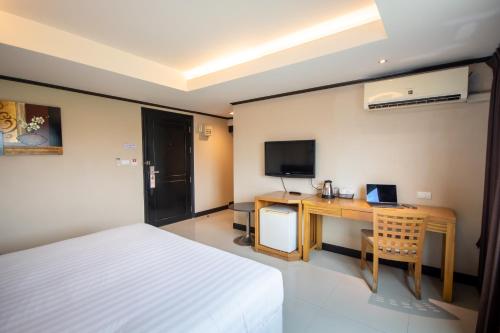 a bedroom with a bed and a desk with a computer at Avana Bangkok Hotel & Convention Centre in Bangna