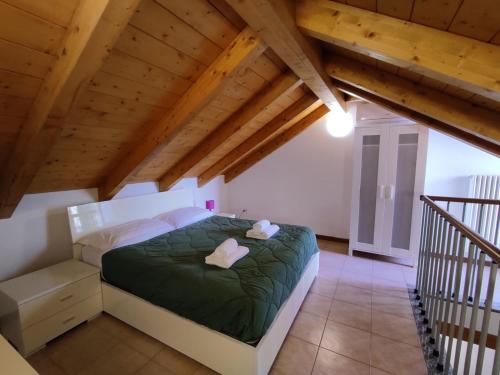 a bedroom with a green bed in a attic at Le Terrazze del Garda - Immobili e Soluzioni Rent in Manerba del Garda