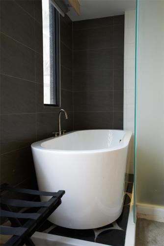 une baignoire blanche dans une salle de bains avec fenêtre dans l'établissement Hotel That, à Kaohsiung