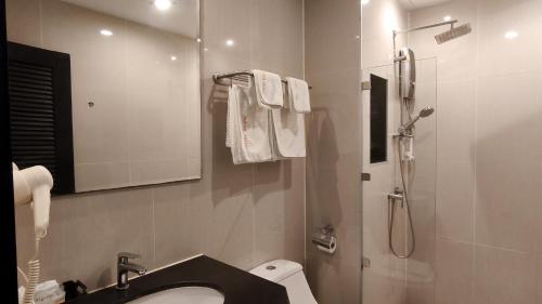 a bathroom with a sink and a shower with a mirror at Avana Bangkok Hotel & Convention Centre in Bangna