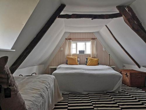a attic bedroom with two beds and a window at 5580-Svaneke-Mor-Markers-Gaenge-13 in Svaneke