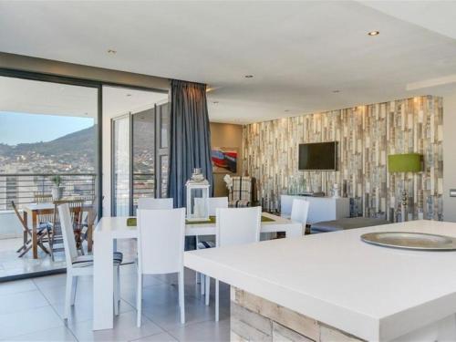 a dining room with a white table and white chairs at Mandela Rhodes Place in Cape Town