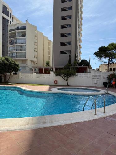 a swimming pool in front of some tall buildings at Calpe apartamento LuXurY nuevo playa centrico parking wifi aire piscina patio in Calpe
