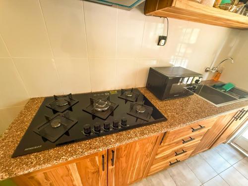 a stove top in a kitchen with a microwave at Nice & Slow Homes in Arusha