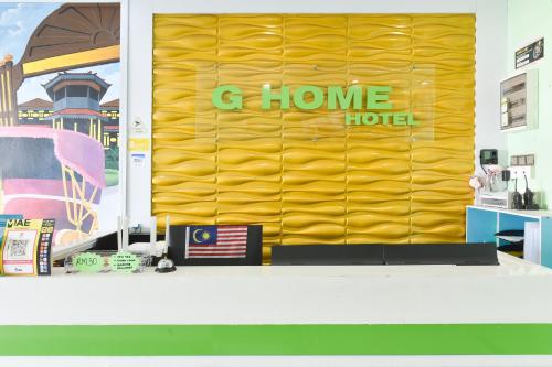 a yellow wall with the words g home hotel on it at Dancenter G Home Hotel in Kota Bharu