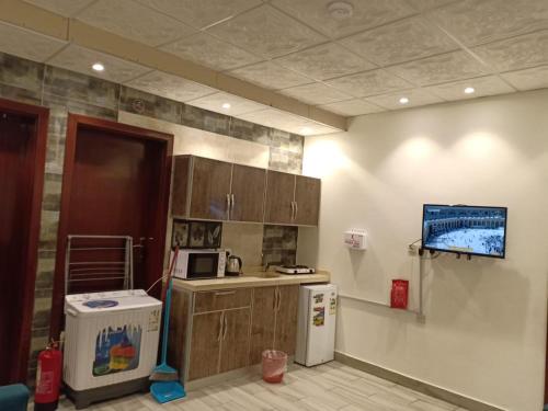 une cuisine avec un comptoir, un micro-ondes et un réfrigérateur dans l'établissement Masa Residences-شقق الماسة, à Médine