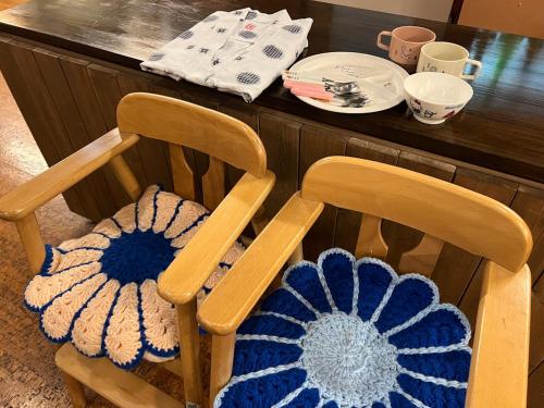a wooden chair with two crocheted cushions on it at Yama no Yado Meiji Onsen in Chino