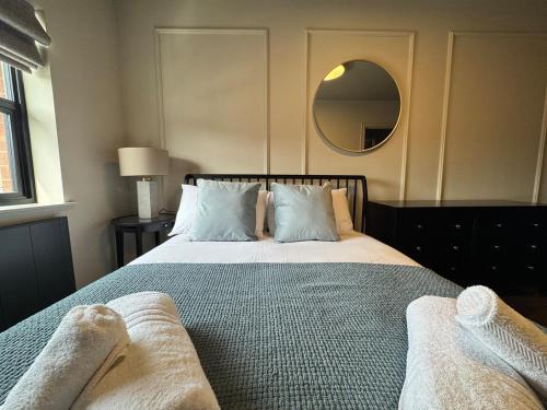 a bedroom with a large bed with a mirror at Apartment 2 - Devonshire Square in Loughborough