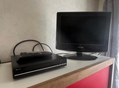 a computer monitor and a keyboard sitting on a desk at Caravane en pleine nature ferme proche de tout in Philippeville