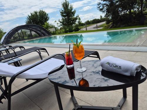 a table with two drinks on top of a patio at Hotel Kőporos Hercegkút in Hercegkút