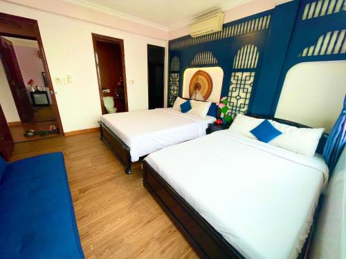 Una cama o camas en una habitación de Pink Lotus Hotel Hue