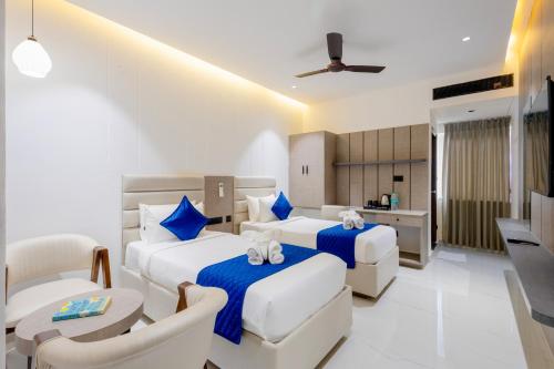una camera d'albergo con due letti e una cucina di La Maniere -Business hotel HITECH City a Hyderabad