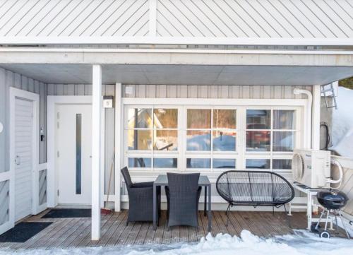a deck with a table and chairs on a house at Tahko North Lodge B 5 in Kuopio