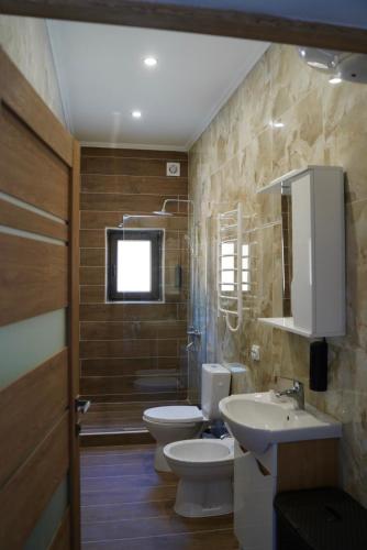 a bathroom with two toilets and a sink at The Selo in Korostovat