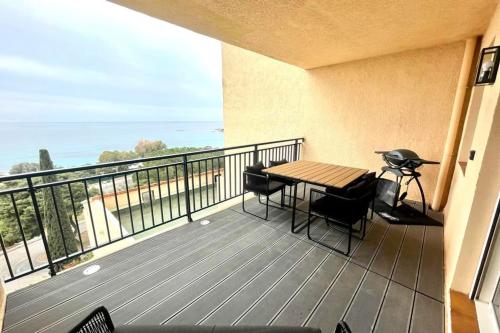 a balcony with a table and chairs and a view of the ocean at Nice And Bright 60 M With Terrace View On The Sea in Ajaccio
