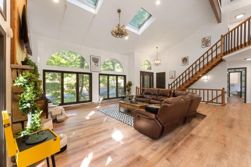 a living room with a couch and a table at Spacious Waterfront Mansion wHot tubPoolTable in East Stroudsburg