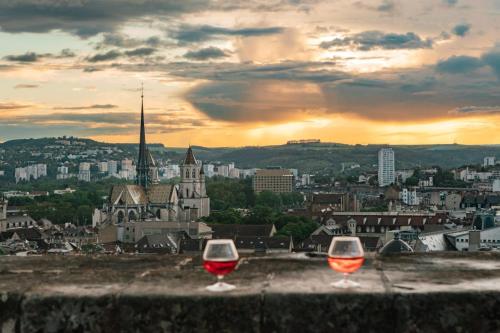 dos copas de vino sentadas en una cornisa con una ciudad en Bel appartement spacieux , lumineux, proche Dijon centre auditorium, en Dijon