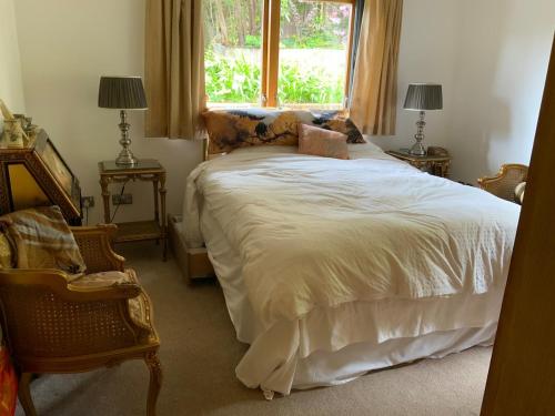a bedroom with a large bed with a window at Oak Cottage - an inclusive peaceful haven in Newport
