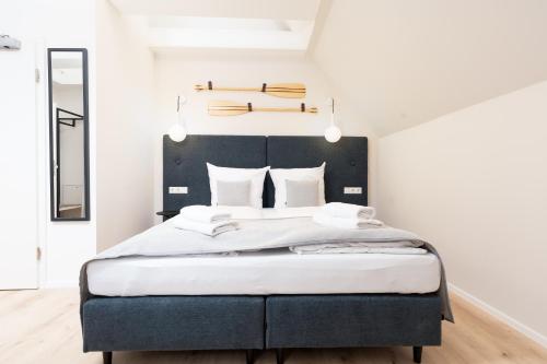 a bedroom with a large bed with a black headboard at Apartments in der Kurgartenstraße - Altstadt - An der Vorderreihe in Travemünde