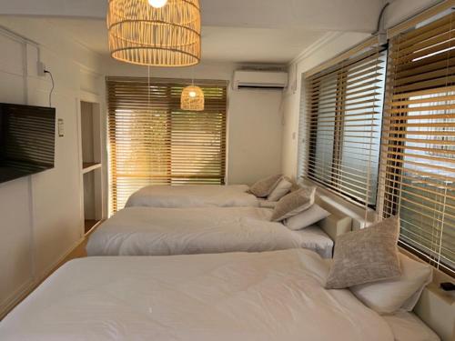 a bedroom with four beds and a chandelier at Yado75 in Nago