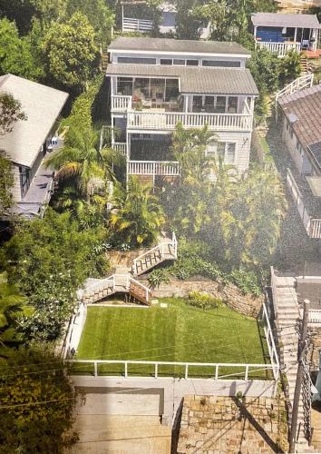 an aerial view of a large house with a green yard at The Lookout - Hamptons Treehouse in Narrabeen