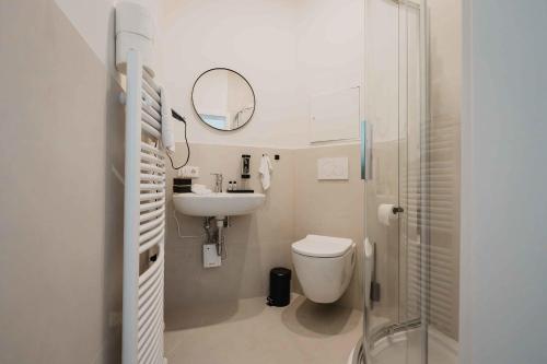 ein Badezimmer mit Toilette, Waschbecken und Spiegel in der Unterkunft Stilvolle Suite in Celle - Frühstück, Kaffee, kostenloser Parkplatz und Wohnküche in Celle