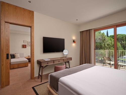 a bedroom with a bed and a desk with a television at Paloma Grida in Belek