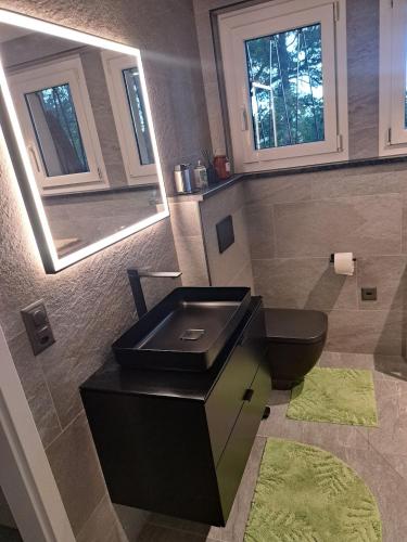 a bathroom with a black sink and a toilet at Appartement Villa du Golf & SPA in Payerne