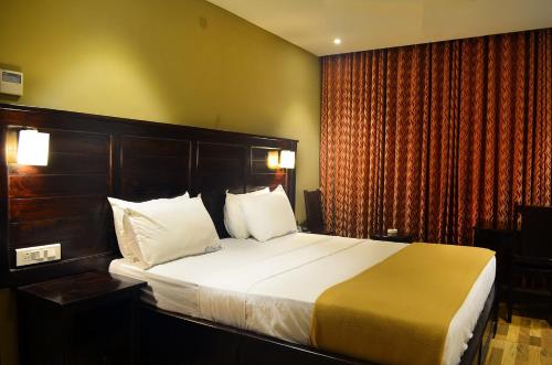 a bedroom with a large bed in a hotel room at Ranis Grand in Coimbatore
