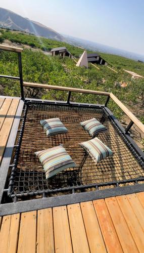 a grill with four pillows on it on a deck at EcoHouse Glamping by ART HOTEL in Bishkek