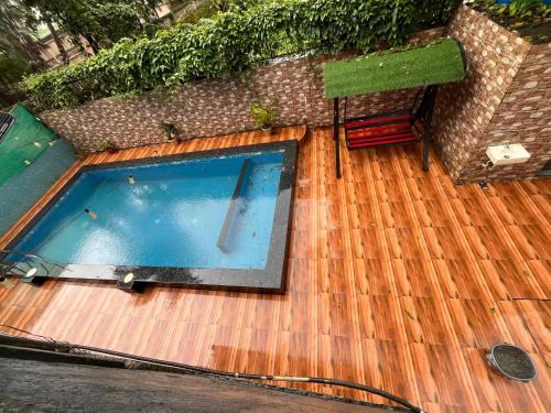 a swimming pool on top of a wooden deck at Enclave Villa 4BHK in Lonavala