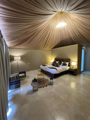 a bedroom with a large bed with a wooden ceiling at Wadi Rum, Hala bubbles in Wadi Rum