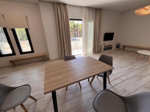 a living room with a wooden table and chairs at Ensueno Apartments Keramoti in Keramotí