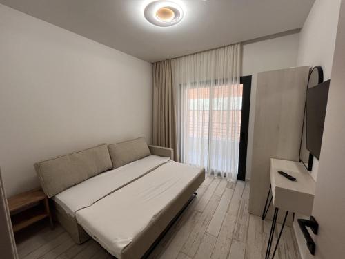 a small bedroom with a bed and a television at Ensueno Apartments Keramoti in Keramotí