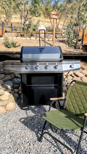 a grill and a chair sitting next to a table at EcoHouse Glamping by ART HOTEL in Bishkek