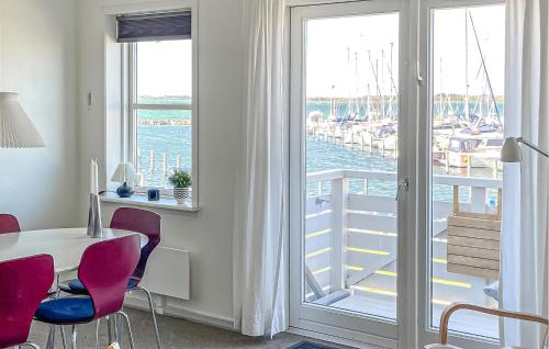a room with a table and chairs and a balcony with boats at Lovely Apartment In Rudkøbing With House Sea View in Rudkøbing