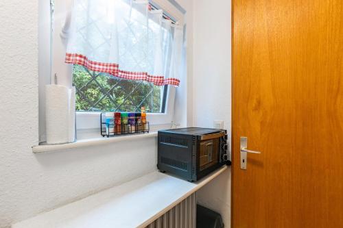 a small microwave sitting on a shelf in a window at Ferienwohnung Schwarzwaldhirsch in Unterkirnach