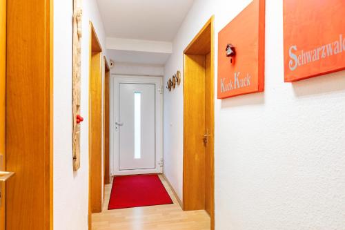 a corridor with a door and a red rug at Ferienwohnung Schwarzwaldhirsch in Unterkirnach
