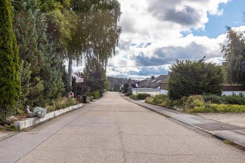 an empty street with trees and bushes at Ferienwohnung Schwarzwaldhirsch in Unterkirnach