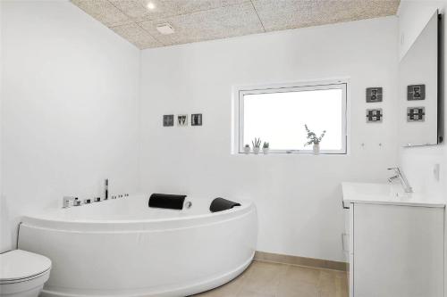 a white bathroom with a tub and a toilet at OH306-Hadsund-Ridestien-3 in Hadsund