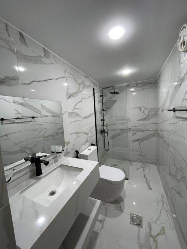 a white bathroom with a toilet and a sink at Wadi Rum, Hala bubbles in Wadi Rum